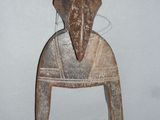 a wooden sculpture of a person sitting on a chair