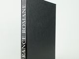 a black book sitting on top of a table next to a white wall