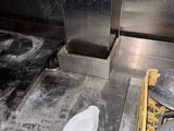 a dirty floor in a kitchen with pots and pans on it