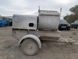 a truck that is sitting in the dirt with a cement mixer on the back