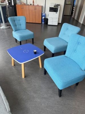 plusieurs chaises et une table dans une pièce où se trouve une table bleue