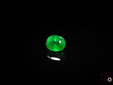 a close up of a green jade stone on a black surface