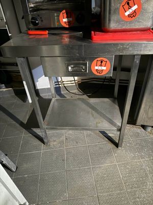 une table en métal sur laquelle est posé un plateau rouge
