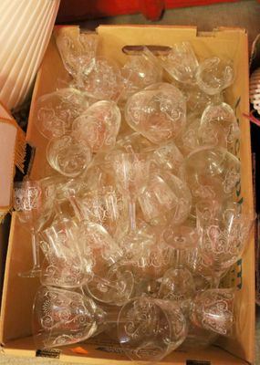 a box full of empty wine glasses sitting on the floor
