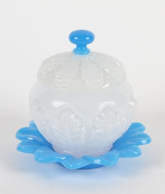 un gros plan d'un bol en verre blanc et bleu posé sur une surface blanche
