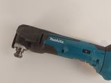 a close up of a cordless drill on a white surface