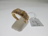 gros plan d'une bague en or avec des diamants sur une surface blanche