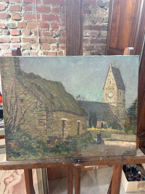 a painting of a church on a easel in front of a brick wall
