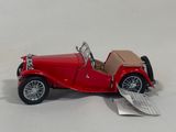 a small red toy car on a white surface