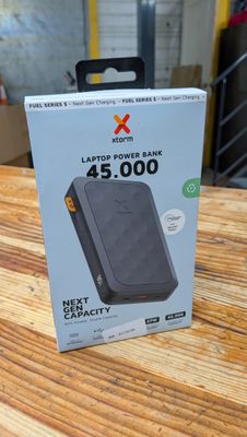 une photo d'une boîte contenant une batterie externe posée sur une table en bois