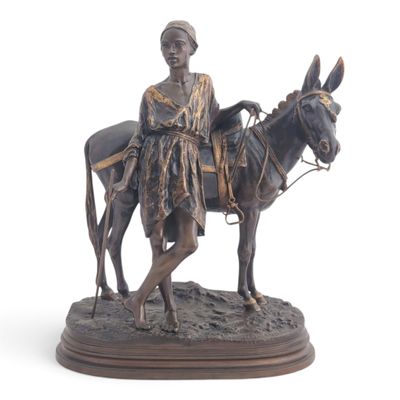 statue of a woman riding a donkey with a basket on her back