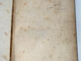 an old open book with writing on it sitting on a table