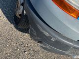a close up of a car ' s front bumper with a denting on it