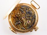 a close up of a pocket watch on a white surface