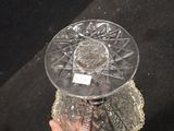 a person holding a glass bowl on a doily doily
