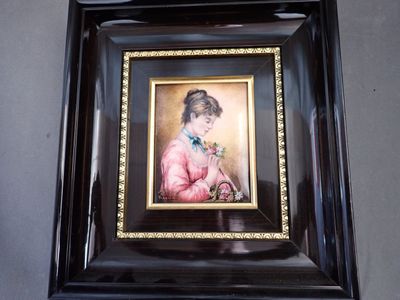 painting of a woman in a pink dress holding a flower in a black frame