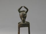deux petites sculptures en bois représentant une femme et un chat, posées sur un tabouret