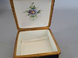 a black and gold box with a blue flower on it