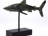 statue d'un requin posée sur un socle noir, sur fond blanc