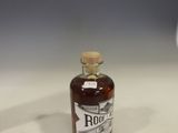 a bottle of rum sitting on a table next to a glass of wine