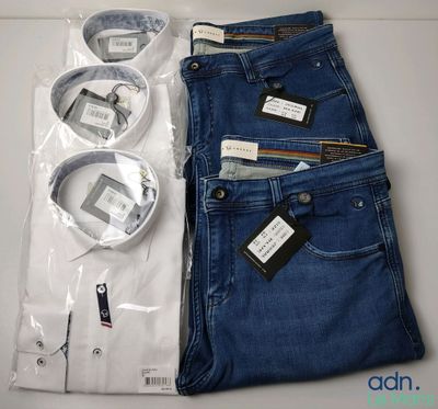 Deux paires de jeans bleus et une chemise blanche sont posées sur une table.