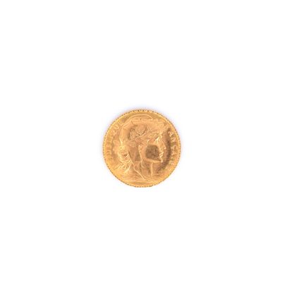 gros plan d'une pièce d'or sur une surface blanche