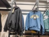 many jackets hanging on a rack in a clothing store
