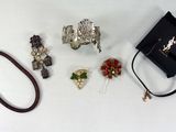de nombreux bijoux posés sur une table à côté d'un sac noir
