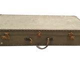 une vieille valise posée sur une surface blanche