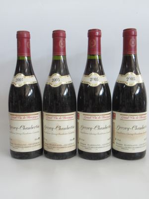 quatre bouteilles de vin sont alignées sur une surface blanche