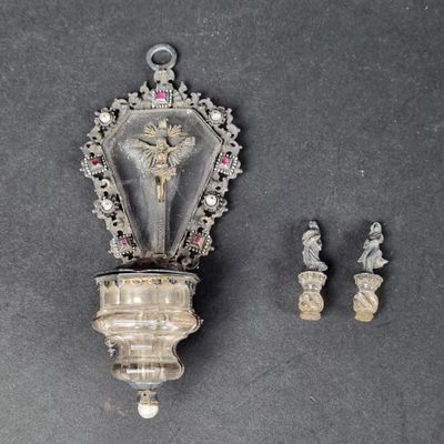 un objet en argent orné d'un crucifix, posé à côté d'autres objets