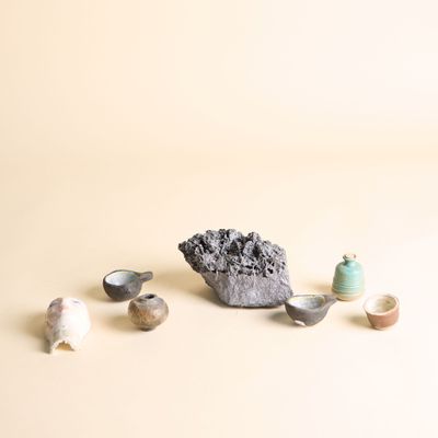 un petit caillou et quelques petits objets posés sur une table