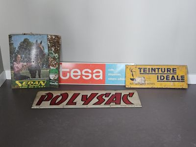 Plusieurs panneaux sont posés sur une table devant un mur blanc.