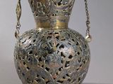 a silver vase with a chain hanging from it