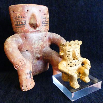 a statue of a man sitting on a chair next to a statue of a bear