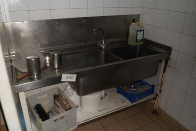a stainless steel sink in the corner of a kitchen