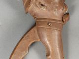 un objet marron surmonté d'une tête d'homme