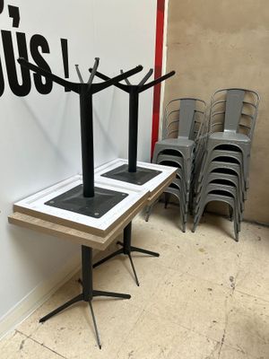 des tables et des chaises dans une pièce où est accrochée une affiche au mur