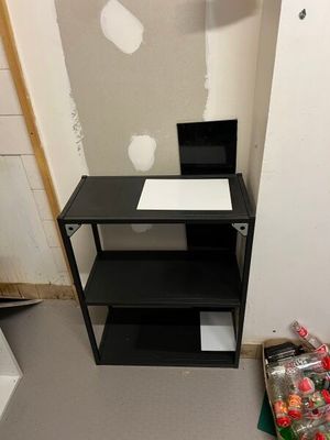 an image of a small room with a desk and shelves
