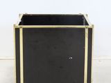 an image of a black and gold planter sitting on top of a white floor