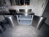 une cuisine en acier inoxydable avec un évier et une cuisinière