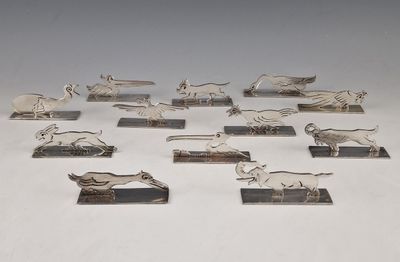 a group of silver figurines of animals on stands
