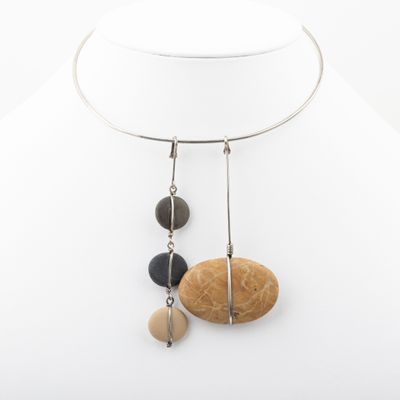 a close up of a necklace on a mannequin with stones