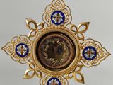 gold and blue clock on a stand on a white surface