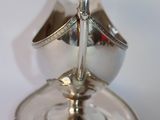 a silver plate with a spoon and saucer on it
