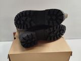 the sole of a pair of black boots on top of a cardboard box