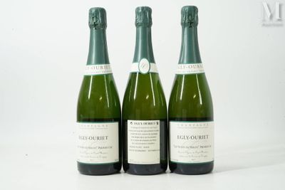 trois bouteilles de vin posées sur une table blanche