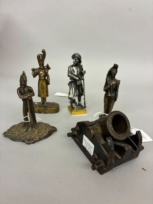 four bronze figurines of different sizes and shapes on a white surface