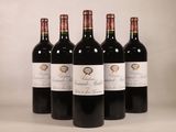 quatre bouteilles de vin rouge sont alignées sur une table