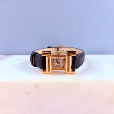 l'image d'une montre en or et noir sur une surface blanche